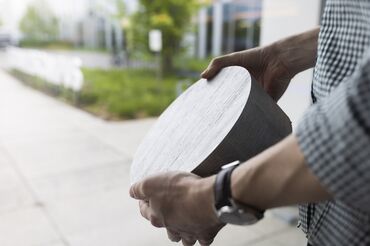 Homme tenant une billette d’aluminium ÉCHANTILLON.
