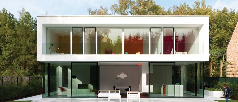 Villa blanche luxueuse avec jardin verdoyant.