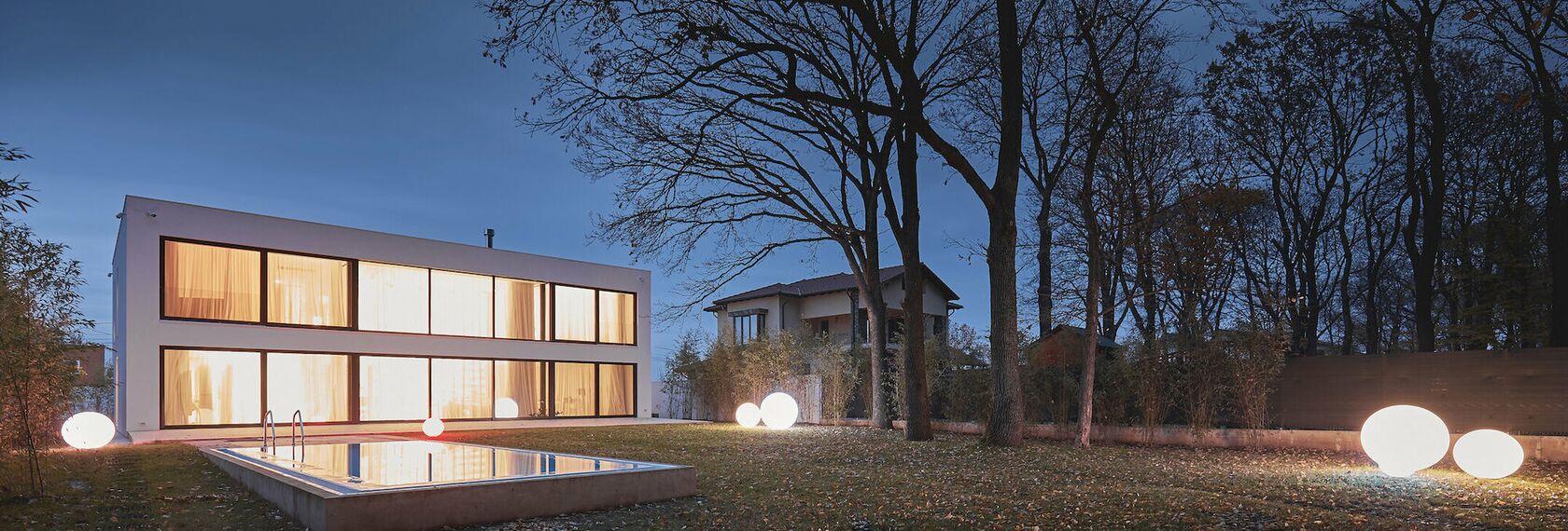 Villa moderne et lumineuse la nuit.