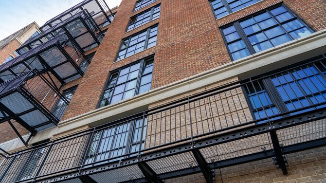 Brick mid-rise apartment building with steel-look windows.