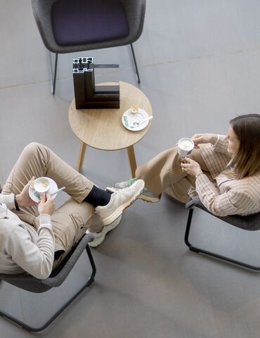 Vue de dessus d’un homme et d’une femme assis à un TABLEAU, buvant un café.