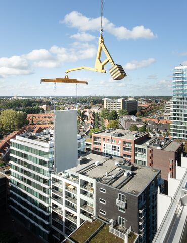 Bâtiment modulaire PANNEAU élevé à côté d’un gratte-ciel.
